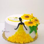 tort z kobietą w żóltej sukni i słonecznikami