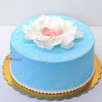 niebieski tort na chrzest z dzidziusiem w płatkach kwiatu