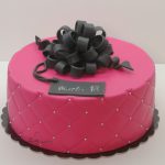 różowy tort z czarną kokardą